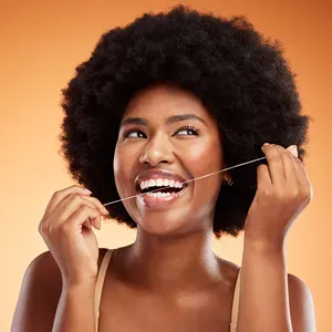 Patient using floss with a confident smile — placeholder